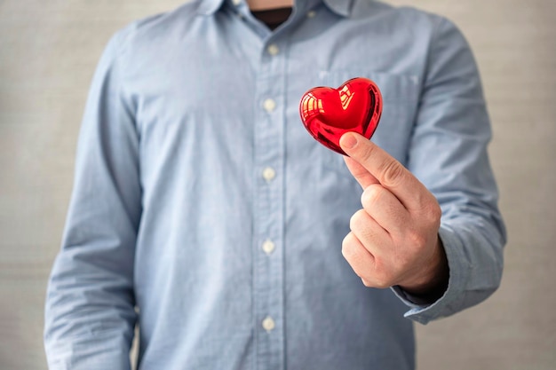 Jovem segurando o coração nas mãos conceito de amor e saúde