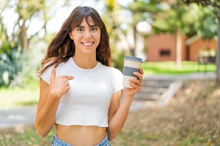 Foto jovem segurando um café para viagem ao ar livre com expressão facial de surpresa