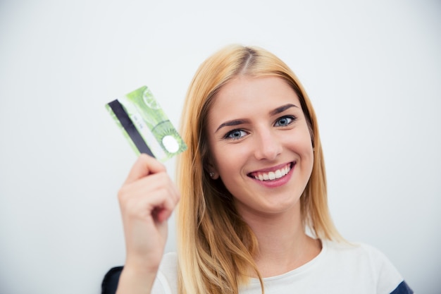 Jovem segurando um cartão do banco