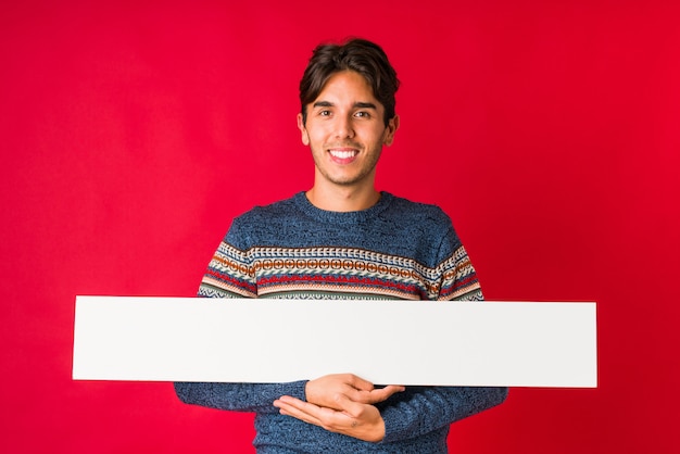 Jovem, segurando um cartaz feliz, sorridente e alegre.