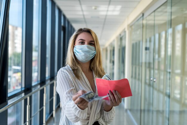 Jovem segurando um envelope e contando dólares no trabalho. conceito de suborno