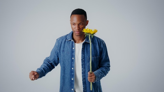 Jovem segurando um girassol amarelo em uma foto de estúdio