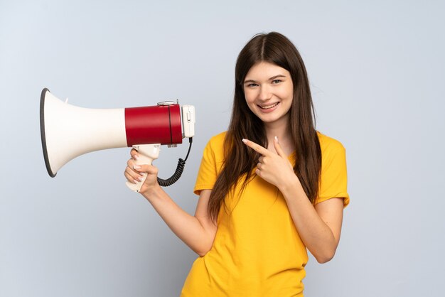 Jovem segurando um megafone e apontando para o lado