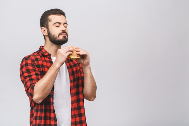 Foto jovem, segurando um pedaço de hambúrguer. faça dieta o conceito isolado contra o fundo branco.
