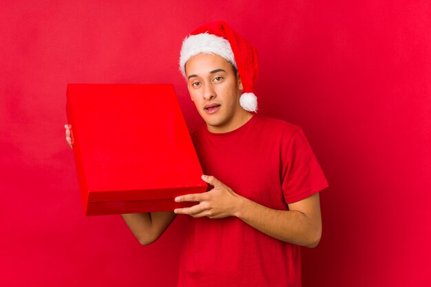 Jovem, segurando um presente no dia de natal