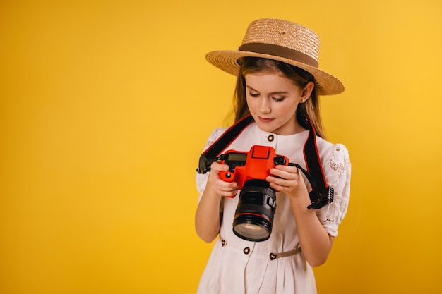 Foto jovem, segurando uma câmera vermelha nas mãos e ver fotos