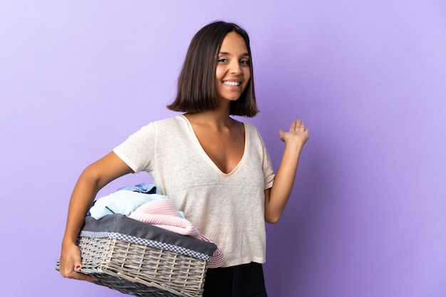 Jovem segurando uma cesta de roupas