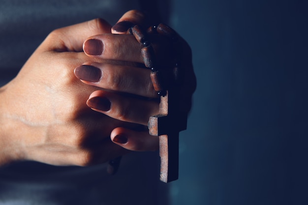 Jovem segurando uma cruz de madeira