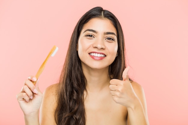 Jovem segurando uma escova de dentes