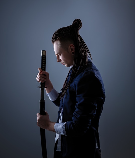 Jovem segurando uma espada de samurai. Foto de glamour.