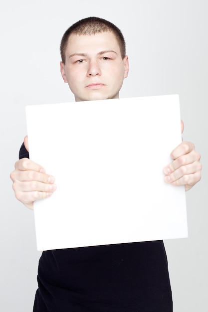 Jovem segurando uma folha em branco vazia