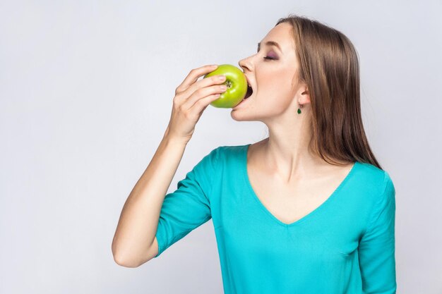 Jovem segurando uma maçã verde