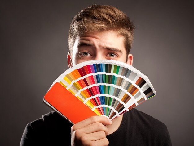 jovem, segurando uma paleta pantone