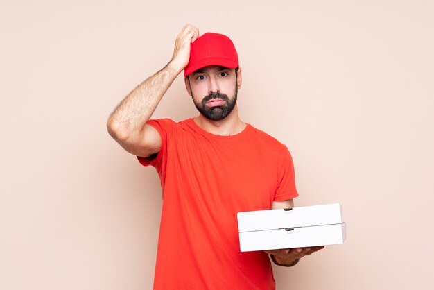 Jovem, segurando uma pizza mais isolado com uma expressão de frustração e não entender