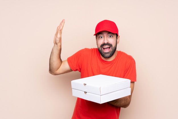 Jovem, segurando uma pizza nervosa e assustada