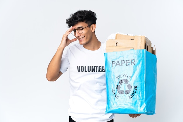 Jovem segurando uma sacola de reciclagem cheia de papel rindo