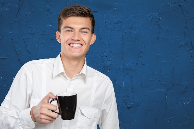 Jovem segurando uma xícara de chá e café quente