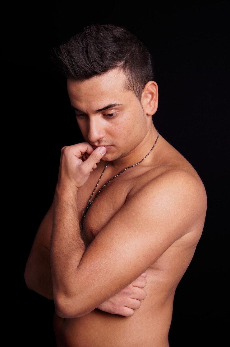 Foto jovem sem camisa contra fundo preto