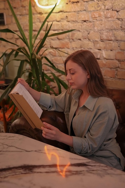 Jovem sentada e lendo um livro à noite