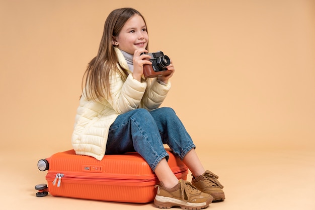 Foto jovem sentada na bagagem para viajar