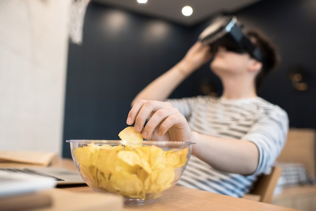 Jovem sentado em óculos vr e tomar o chip