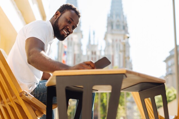 Jovem sentado em um terraço lendo um artigo