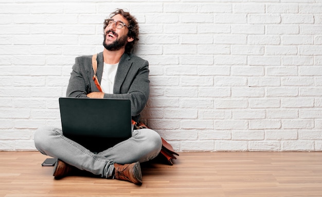 Jovem sentado no chão com um satisfeito e feliz