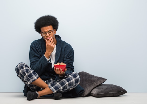 Jovem sentado tomando café da manhã