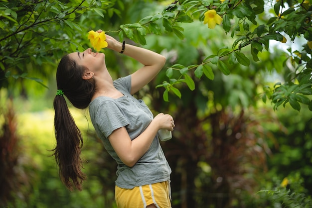 Jovem sentindo o cheiro de flores amarelas