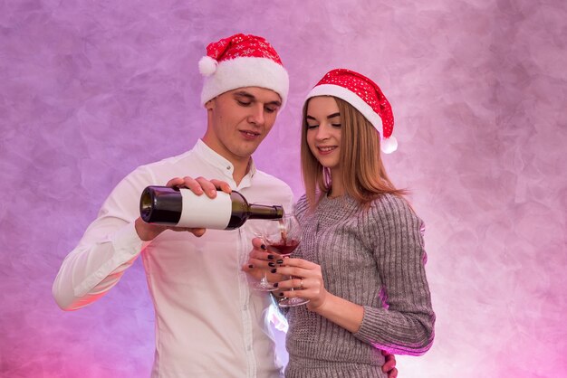 Jovem servindo vinho em copos para a namorada. Conceito de celebração do dia dos namorados