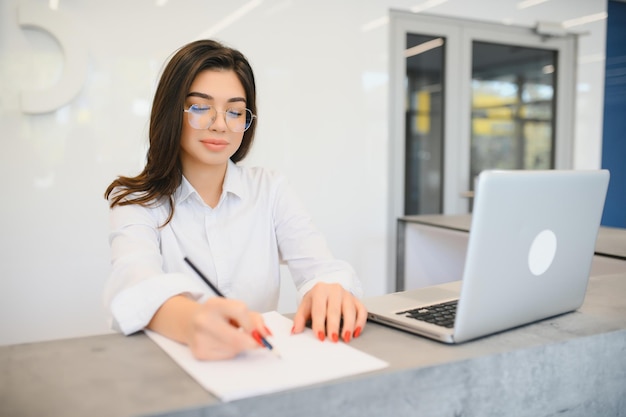 Jovem simpática atrás do administrador da recepção