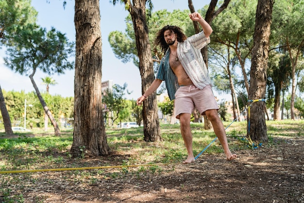 Foto jovem slackline no parque da cidade durante o dia de verão