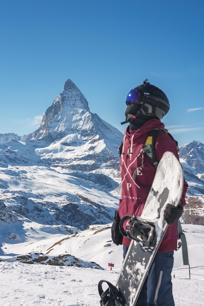 Jovem snowboarder passando as férias de inverno em zermatt perto do famoso pico de matterhorn