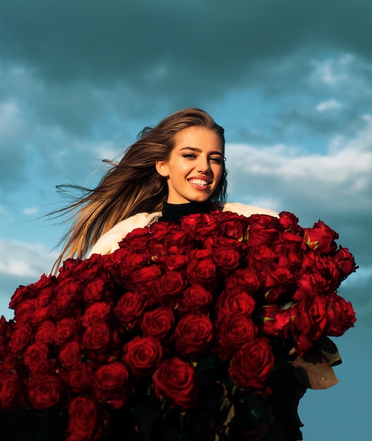 Jovem sorridente aprecia flores de rosa vermelha conceito do dia dos namorados melhores ideias para o dia dos namorados
