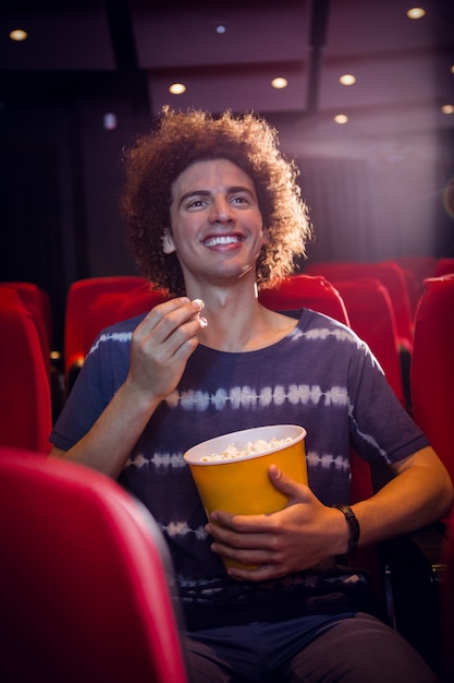 Foto jovem sorridente assistindo um filme