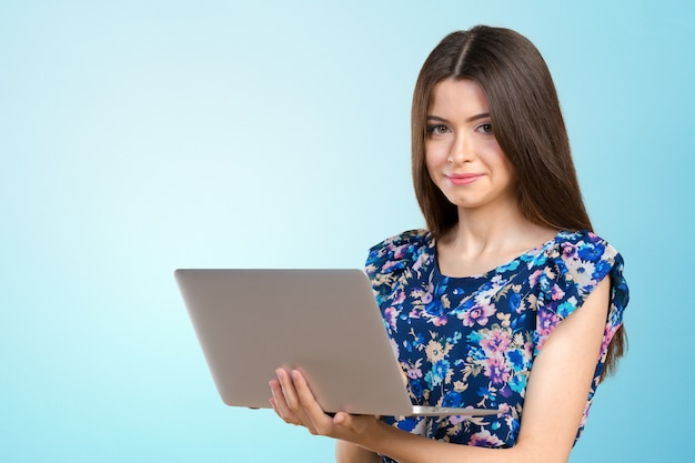 Jovem sorridente atraente segurando o computador portátil