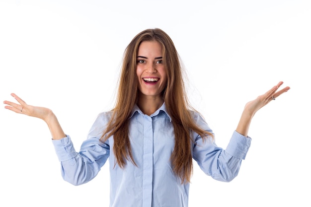 Jovem sorridente com cabelo comprido na camisa azul mostrando felicidade em fundo branco no estúdio