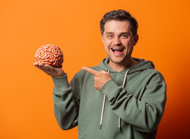 Jovem sorridente com um cérebro em laranja
