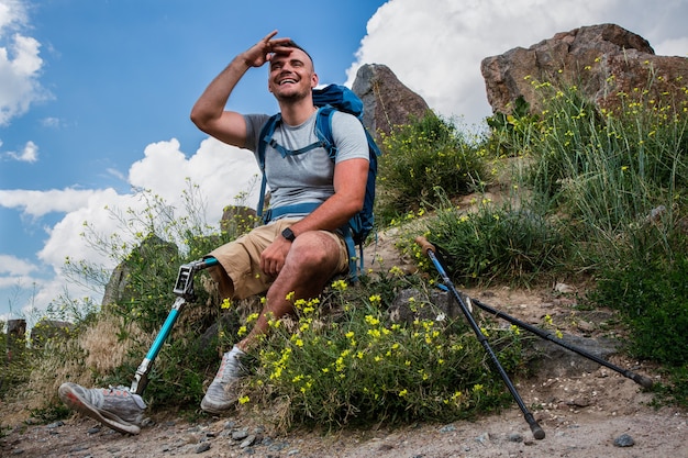 Jovem sorridente e ativo com distúrbios físicos, apreciando vistas naturais enquanto descansa no fim de semana