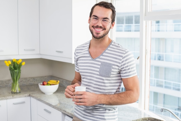 Jovem sorridente e segurando café