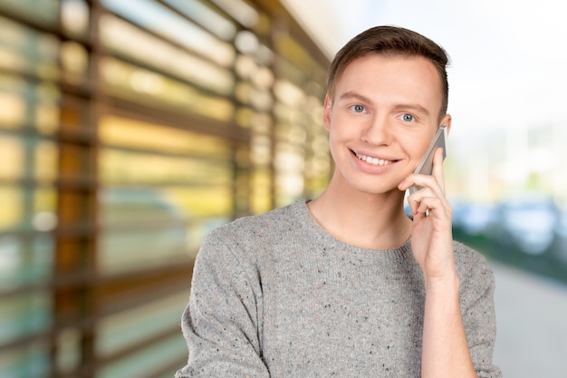 Jovem sorridente, falando no telefone celular