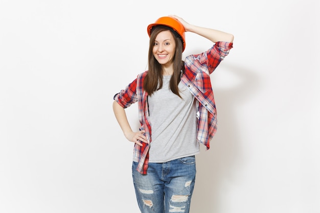 Jovem sorridente linda mulher com roupas casuais e capacete protetor laranja construção isolado no fundo branco. Instrumentos, acessórios para sala de apartamento de renovação. Conceito de casa de reparo.