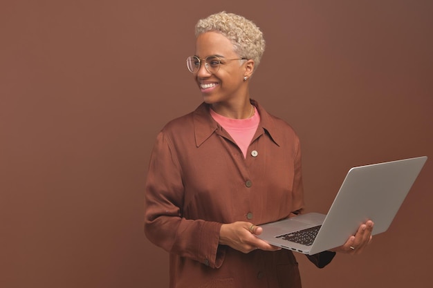 Jovem sorridente mulher afro-americana freelancer segurando laptop aberto