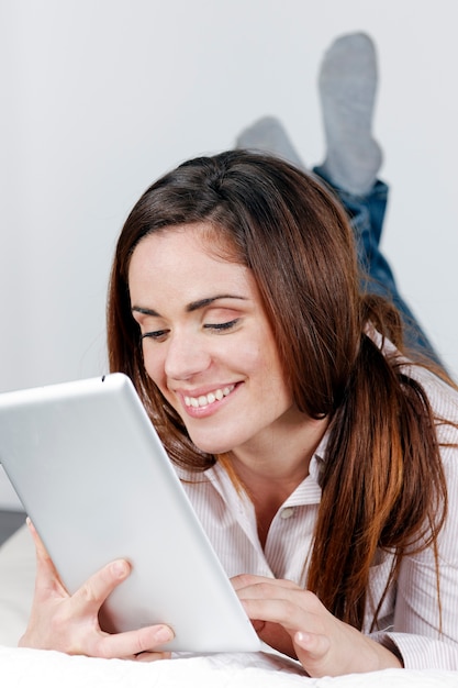 Jovem sorridente no sofá com um tablet