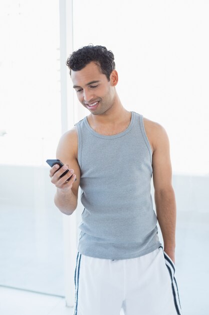 Jovem sorridente olhando para celular