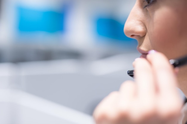 jovem sorridente operador de call center feminino fazendo seu trabalho com um fone de ouvido