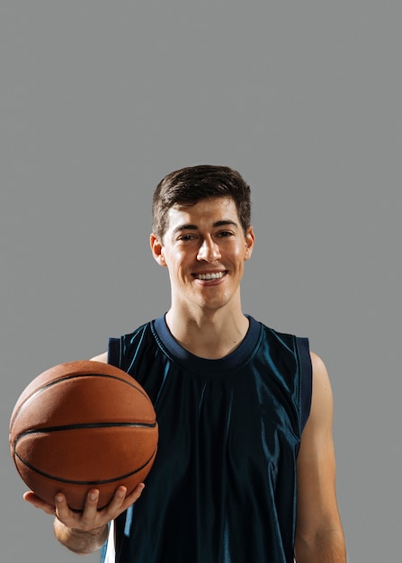 Jovem sorridente segurando seu basquete