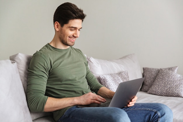 Jovem sorridente usando computador portátil