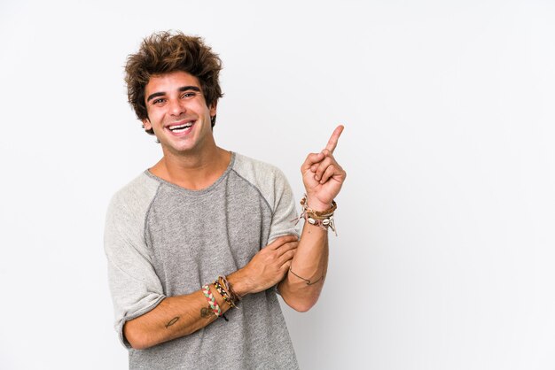 Foto jovem, sorrindo alegremente apontando com o dedo indicador fora