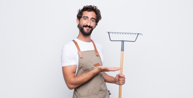 Jovem sorrindo alegremente, sentindo-se feliz e mostrando um conceito no espaço da cópia com a palma da mão